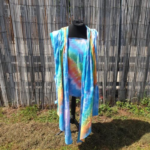 A rainbow dyed wrap on a mannequin photographed in a garden